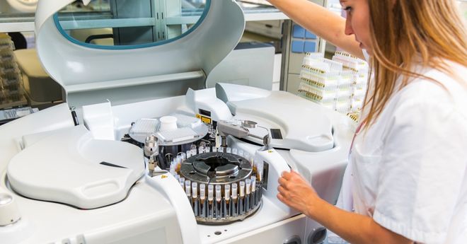 Female lab technician preparing centrifuge. 