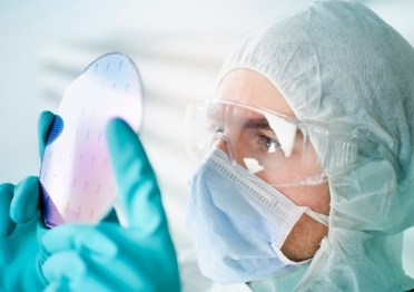 Microelectronics engineer looking through a wafer